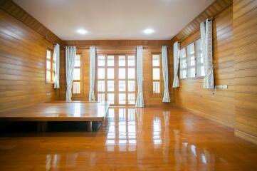 Spacious wooden living room with large windows