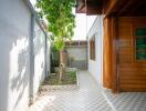 side yard with tiled pathway and tree