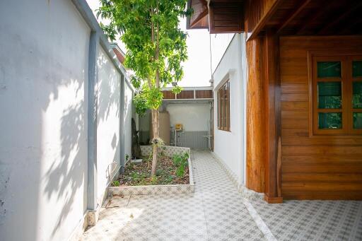 side yard with tiled pathway and tree