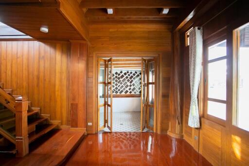 A wooden living space with stairs and large windows