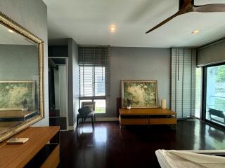 spacious bedroom with large mirror and windows