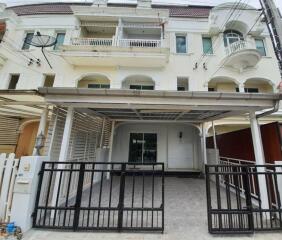 Photo of a modern three-story townhouse with a covered carport