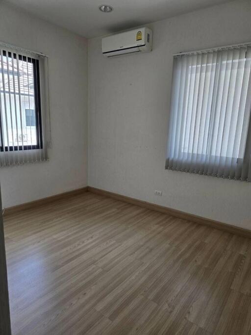 Bedroom with wooden floor and air conditioning unit