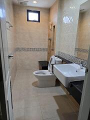 Modern bathroom with sink, toilet, and shower area