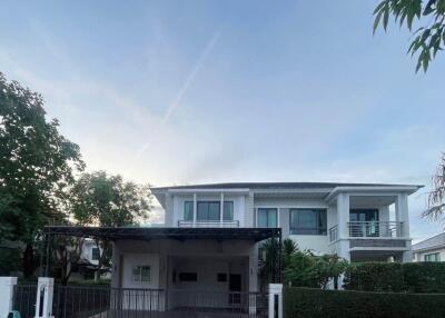 Modern two-story white house with a gated driveway