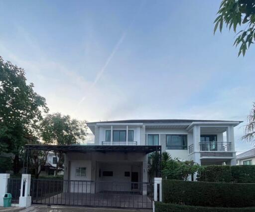 Modern two-story white house with a gated driveway