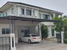 Two-story modern house with car parked in driveway