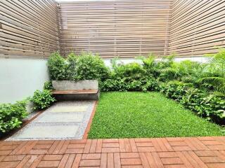 Well-maintained backyard with a lawn, plants, and a bench