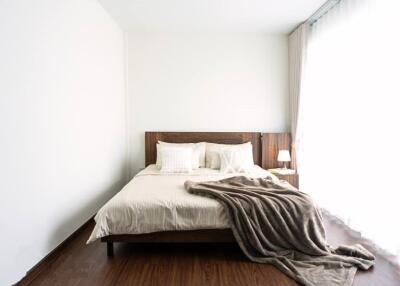 Modern bedroom with wooden flooring and large window
