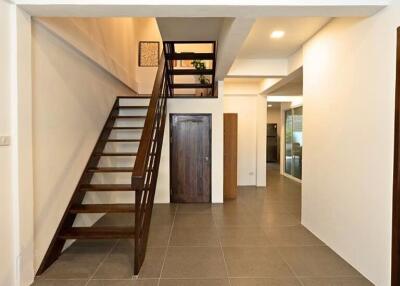 View of a hallway with staircase and door