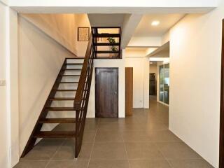 View of a hallway with staircase and door