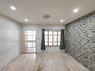 Living room with wooden flooring and stone accent wall