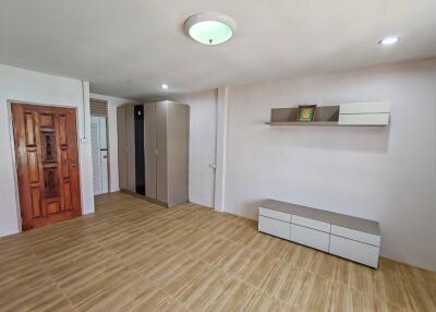 Minimalist bedroom with wooden door and tile flooring