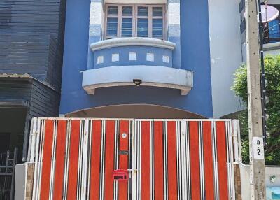 Two-story residential house with a modern facade and gated entrance