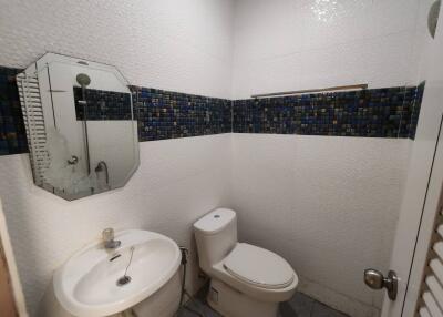 Bathroom with sink, toilet, mirror, and tiled walls