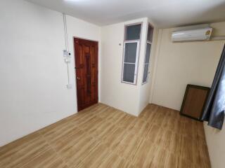 Empty bedroom with wooden floor and air conditioning unit