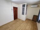 Empty bedroom with wooden floor and air conditioning unit