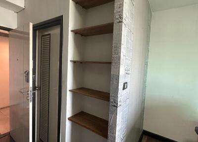 Corridor with wooden shelves and white brick wall