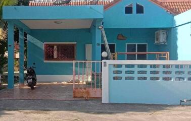 Front view of a house with a covered porch and a gated driveway