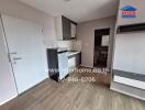 Compact kitchen area with wooden flooring and built-in cabinets