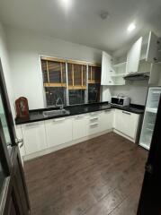 Modern kitchen with white cabinets and black countertops