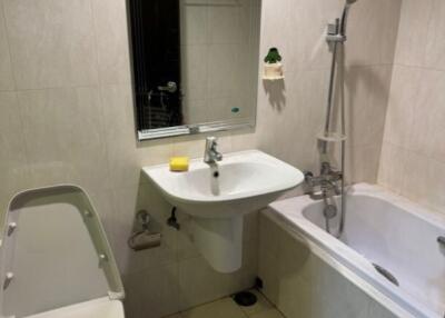 Bathroom with toilet, sink, mirror, and bathtub with shower