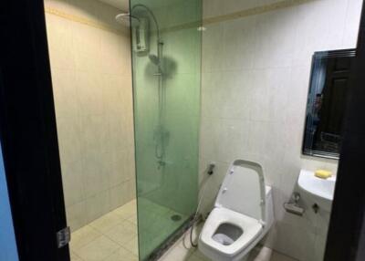 Modern bathroom with glass-enclosed shower and wall-mounted toilet.