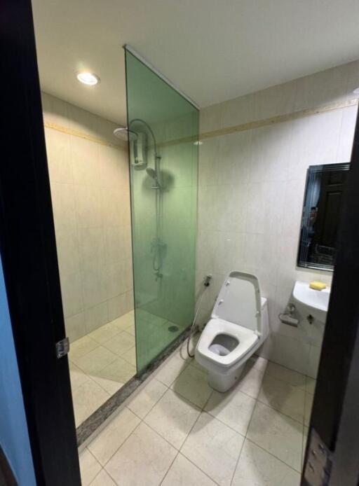 Modern bathroom with glass-enclosed shower and wall-mounted toilet.