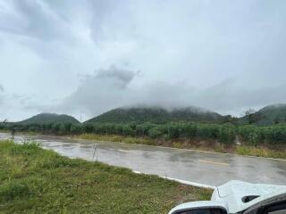 A view of a road with hills and fog in the background