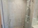 Modern walk-in shower with glass doors and wall-mounted showerhead