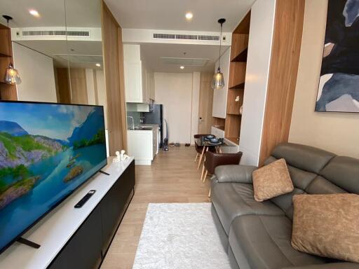 Modern living room with TV and kitchen in background