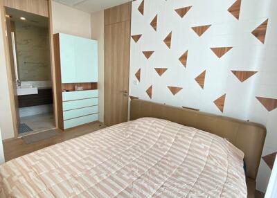Modern bedroom with patterned wall and beige bedspread