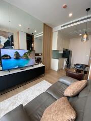 Modern living area with a flat-screen TV, kitchen, and dining table