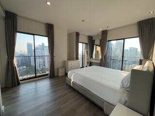 Modern bedroom with large windows and city view