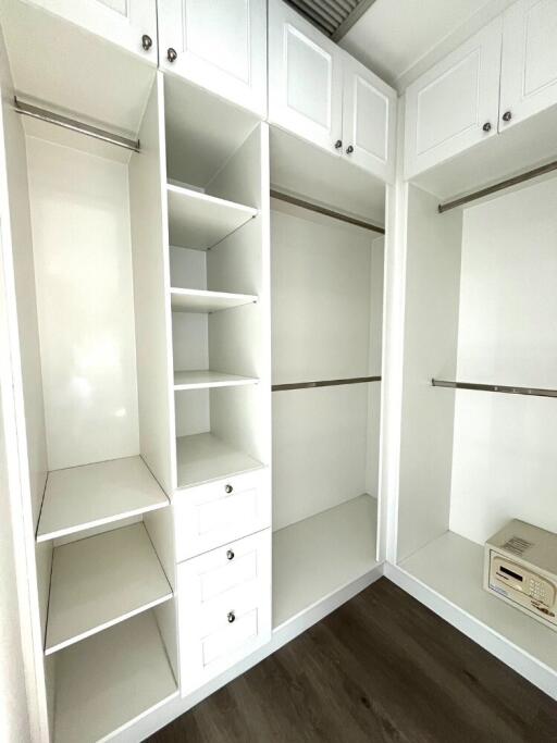 Spacious walk-in closet with white shelving and drawers