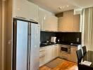 Modern kitchen with stainless steel appliances and glossy cabinets