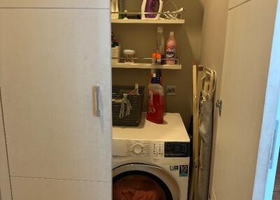 Compact laundry nook with washing machine and storage shelves