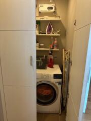 Compact laundry nook with washing machine and storage shelves