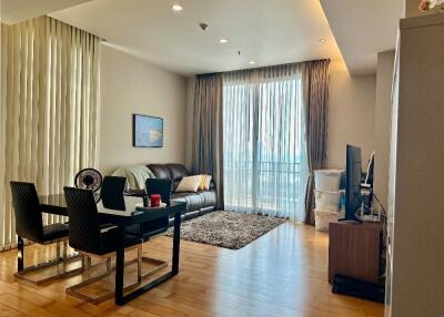 Contemporary living room with dining area, sofa, TV, and large windows