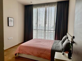 Modern bedroom with large window, bed, and nightstand