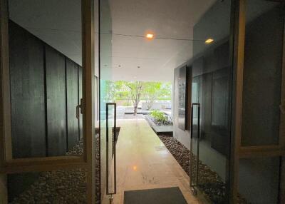 Modern building entrance with glass doors and garden view