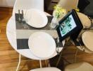 Small modern dining area with white chairs and a round table