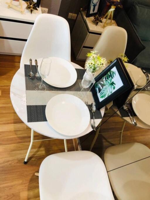 Small modern dining area with white chairs and a round table