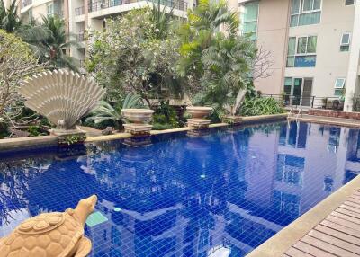 Outdoor Swimming Pool with surrounding greenery and water feature