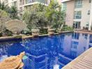 Outdoor Swimming Pool with surrounding greenery and water feature