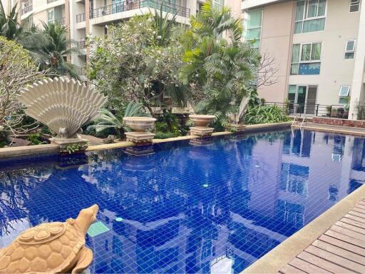 Outdoor Swimming Pool with surrounding greenery and water feature