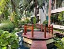 Beautiful garden area with wooden bridge and lush greenery.