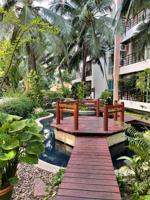 Beautiful garden area with wooden bridge and lush greenery.