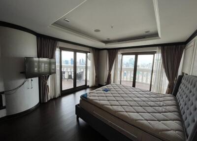 Spacious bedroom with a large bed and balcony view