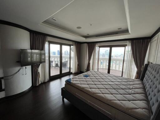 Spacious bedroom with a large bed and balcony view